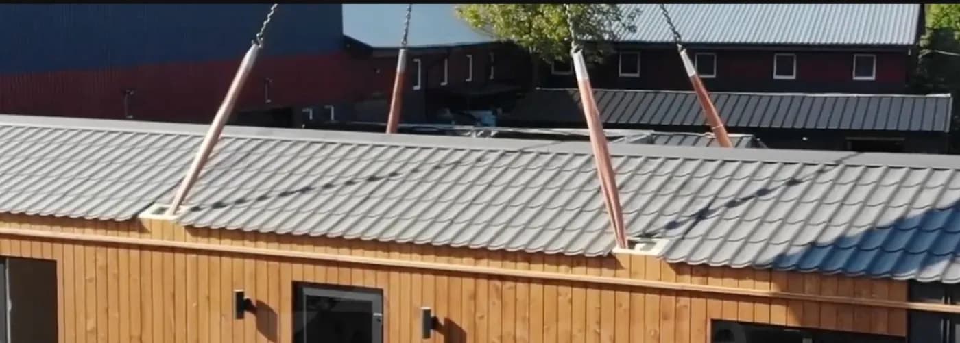 Levage d'un module à la grue : par le haut avec un châssis acier, par sangles autour du caisson pour une ossature bois seule.